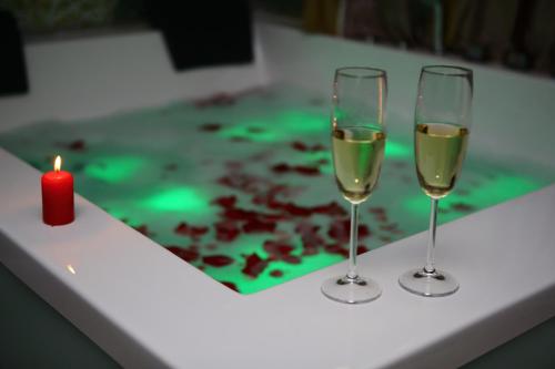 two glasses of wine and a candle on a table at MELISS EVENTS in Craiova