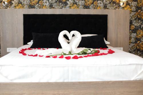 two swans on a bed with flowers on it at MELISS EVENTS in Craiova