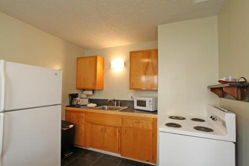 a kitchen with a white refrigerator and wooden cabinets at Lido Palms Resort & Spa in Desert Hot Springs