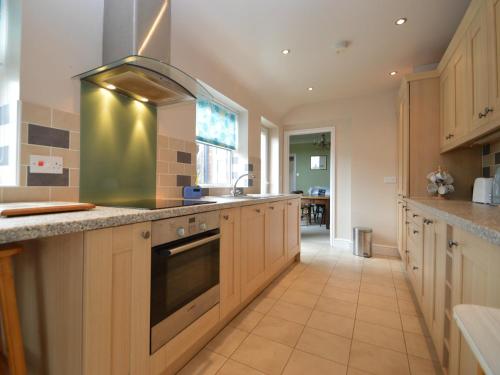 a large kitchen with wooden cabinets and a sink at Lime House in Newark-on-Trent