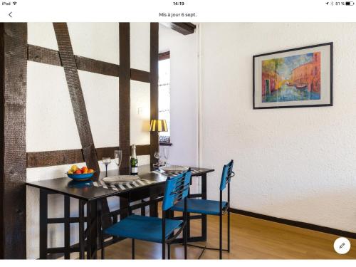 une salle à manger avec une table et des chaises bleues dans l'établissement Little Bartholdi - Appartement Colmar Hyper Centre, à Colmar