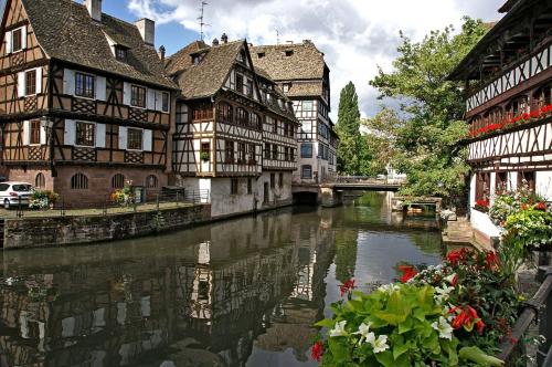 um grupo de edifícios ao lado de um rio em uma cidade em The Little Studio em Estrasburgo