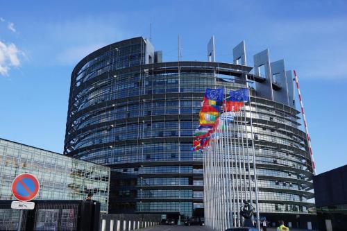 a tall glass building with flags in front of it at The Little Studio in Strasbourg