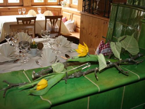 a table with a green table cloth with yellow flowers on it at Gasthaus Linde in Hofstetten