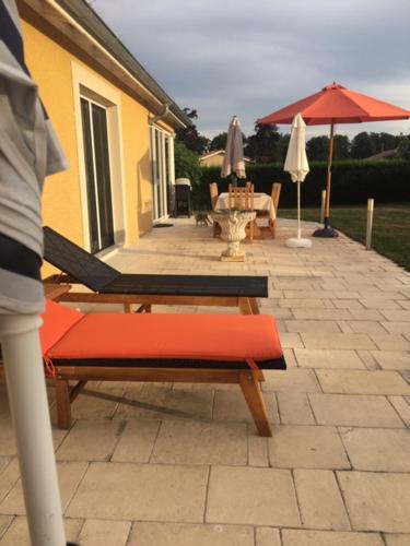 a patio with two chairs and an umbrella at lamaison-d'ose in Romans