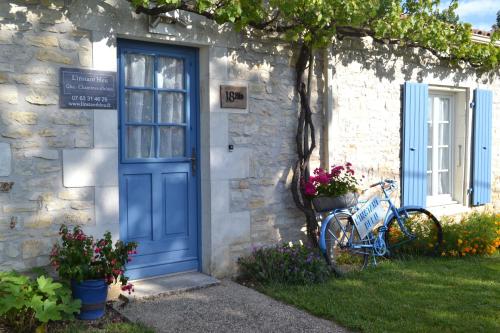 uma porta azul de uma casa de pedra com uma bicicleta estacionada lá fora em L'instant bleu em Marans