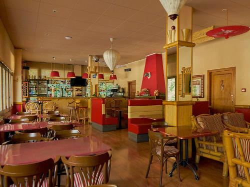 厄茨的住宿－派瑞尼酒店，一间带桌椅的餐厅和一间酒吧
