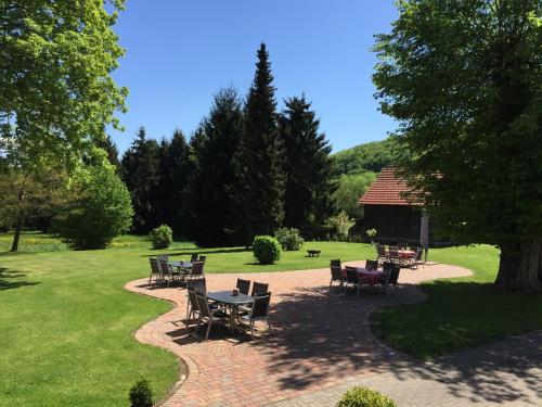 a patio with tables and chairs in a park at Jagdschloß Walkenried in Walkenried