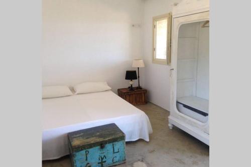 a bedroom with a white bed and a mirror at Stazzu Bandera in Aglientu