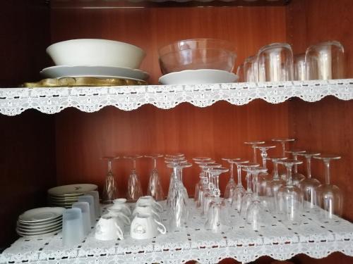 a white shelf with glasses and dishes on it at Rosso Tirano in Tirano
