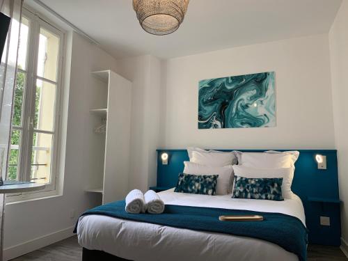 una camera con un grande letto con testiera blu di Logis St Joseph ad Angers