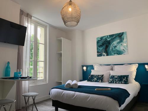 um quarto com uma cama grande em azul e branco em Logis St Joseph em Angers