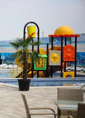 a playground in a swimming pool with a palm tree at MELISS EVENTS in Craiova