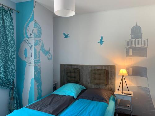 una camera da letto con un letto con un murale di robot sul muro di La Bergerie a Le Pouliguen