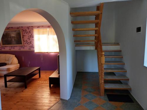 uma escada numa sala de estar com uma escada em Viesu nams Purenes em Vecmuiža