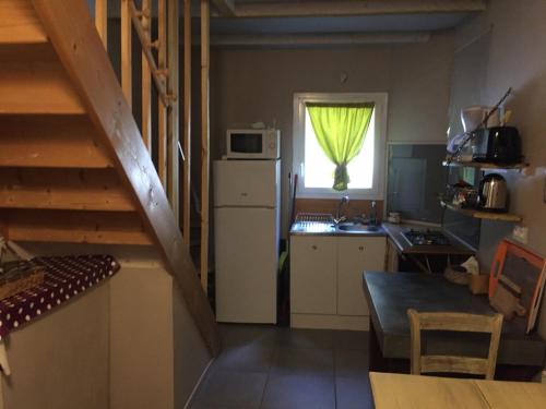 a kitchen with a staircase and a window with a microwave at Accacia Home in Ferrières