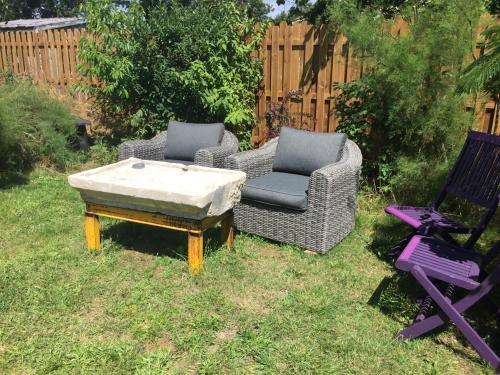 two chairs and a coffee table in a yard at Accacia Home in Ferrières