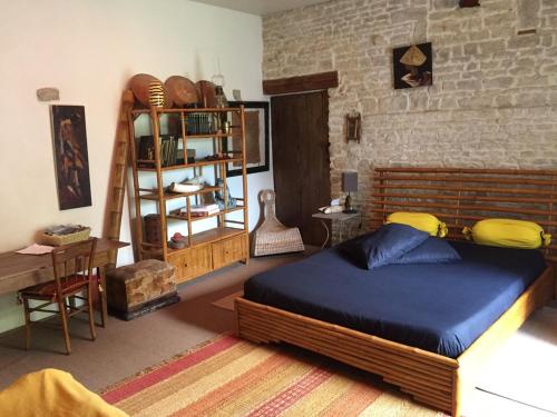 een slaapkamer met een groot bed en een plank bij Accacia Home in Ferrières