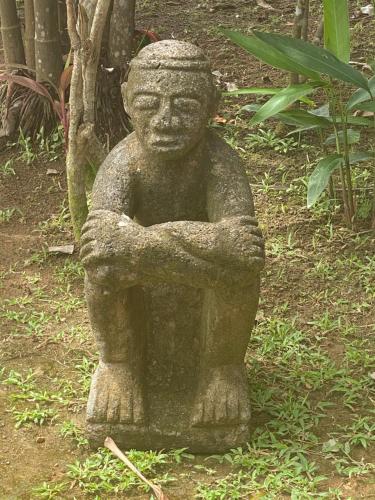 a statue of a stone statue of a person at Uvita Oasis Retreat with Villa Cabins and Apartment in Uvita