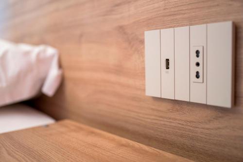 a white light switch on a wooden wall at Vino e Turismo in San Defedente di Cervasca