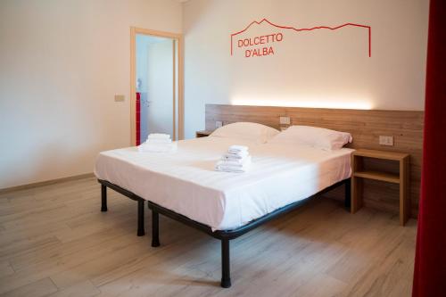 a bed in a room with a sign on the wall at Vino e Turismo in San Defedente di Cervasca