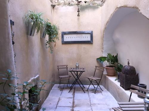 a patio with chairs and a table with plants at Maison Anila in Barjac