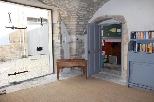 Cette chambre comprend une porte, une table et une fenêtre. dans l'établissement Maison Anila, à Barjac