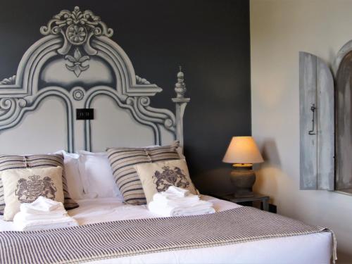 a white bed with a large headboard and pillows at Maison in Bushmills