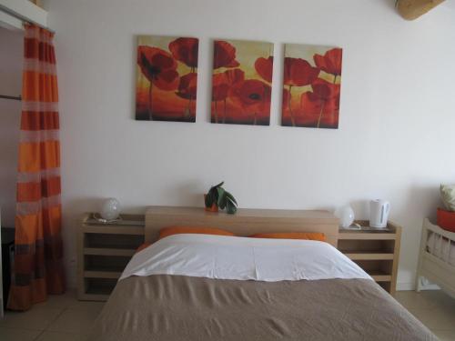um quarto com uma cama e duas pinturas na parede em Lou Cardalines em Bédoin