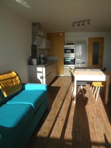 - un salon avec un canapé bleu et une table dans l'établissement Appartement vue panoramique mer, prêt de vélos, WIFI, à Quiberon