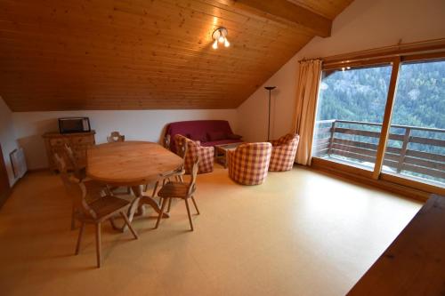 une salle à manger avec une table et des chaises et une fenêtre dans l'établissement VAUJANYLOCATIONS - Les Balcons de Vaujany, à Vaujany