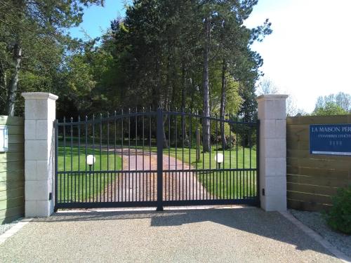 una puerta negra con un cartel delante de un parque en La Maison Periot, en Trévières