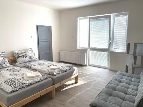 1 dormitorio con 2 camas y 2 ventanas en Apartmány Zahrádky, en Hráz
