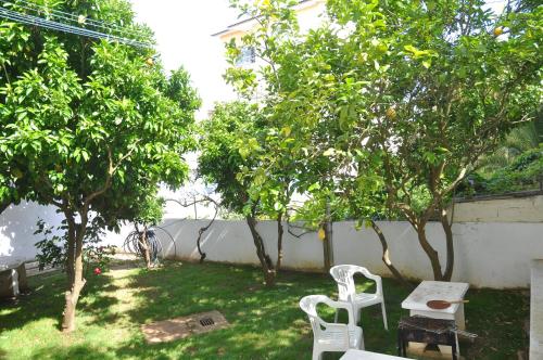 a yard with two chairs and a table and trees at Manelisa Cascais in Cascais
