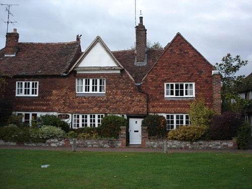 a brick house with a white door in a yard at The Old Manor House B & B in Brasted