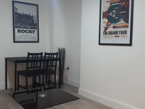 a table and chairs in a room with posters on the wall at Marble Apartments Broadway Two in London