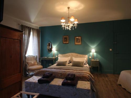 a bedroom with a large bed and a chandelier at La Mare Aux Bambous in Couffy