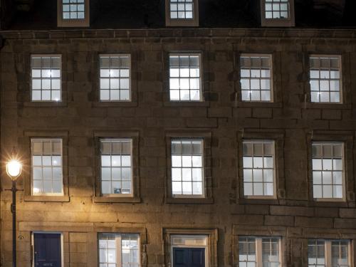 a brick building with windows at night at Marischal Apartments in Aberdeen