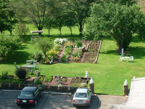 een tuin met twee auto's geparkeerd op een parkeerplaats bij Marshlands Inn in Sackville
