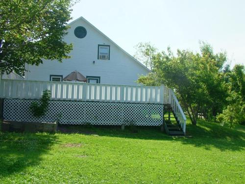 a white house with a porch and an umbrella at Marshlands Inn in Sackville