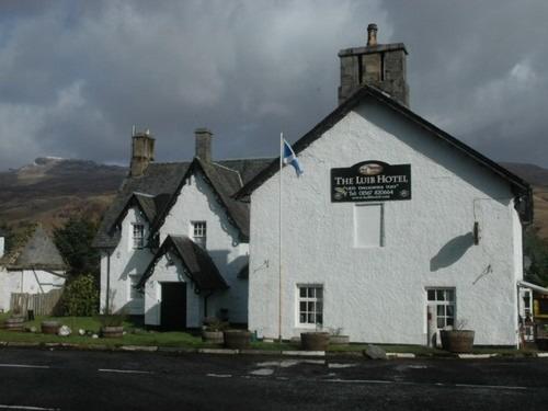 a large white building with a sign on it at Luib Hotel in Killin