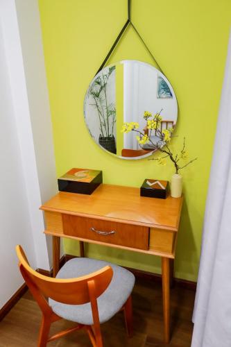 a desk with a mirror and a chair in a room at Chez Mimosa Local in Ho Chi Minh City