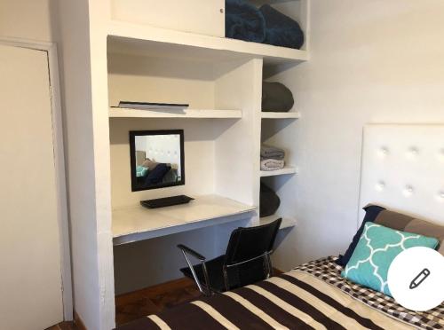 a bedroom with a bed and a mirror and shelves at Agradable* y Cómodo Departamento Familiar (WiFi) in Chihuahua