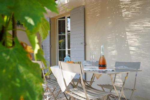 - une table avec 2 chaises et une bouteille de vin dans l'établissement Cottage Aixois Mas de la Granette, à Aix-en-Provence