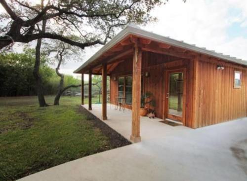 a small wooden cabin with a porch in a park at Live Oaks Bed and Breakfast in Uvalde