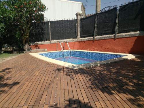 a swimming pool on a brick patio with a fence at Hotel Villa Maria in Fuentes de B&eacute;jar