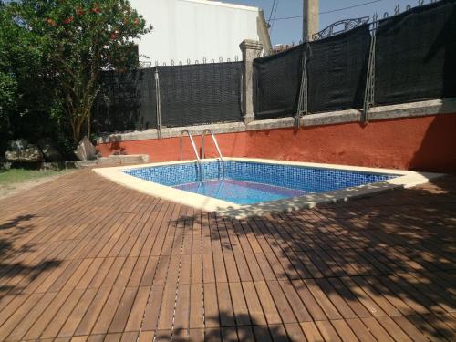 a swimming pool on a brick patio with a fence at Hotel Villa Maria in Fuentes de Béjar