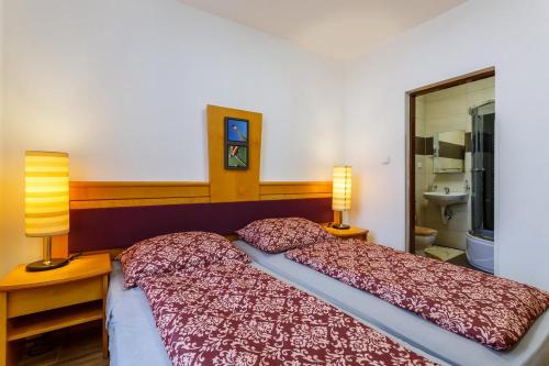 sypialnia z łóżkiem z 2 lampami i umywalką w obiekcie Restaurace a penzion U nádraží w mieście Studénka