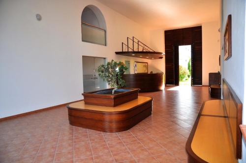 - un salon avec une plante en pot au sol dans l'établissement Vacancéole - Résidence Sognu di Rena, à San-Nicolao