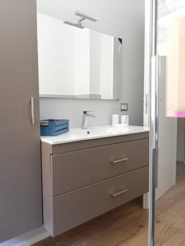 a kitchen with a sink and a mirror at HouseSandra Mare & Sole in Alghero